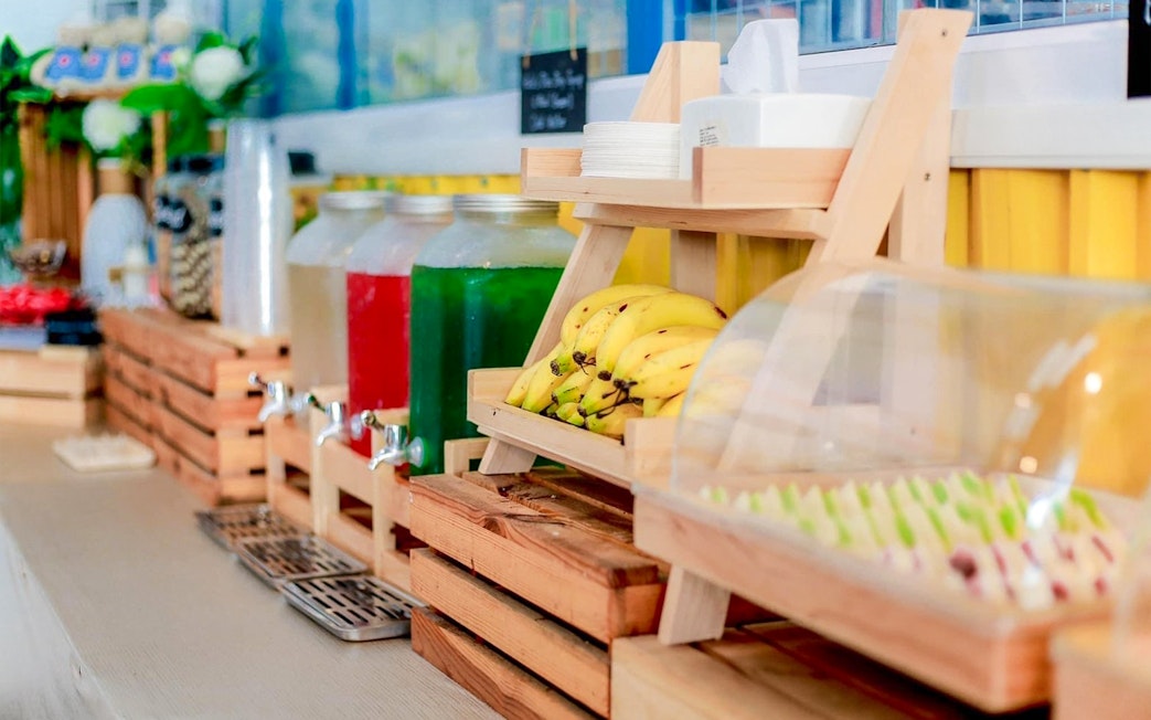 Buffet with bananas, drinks, and assorted food items in Phuket.