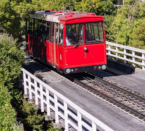 Wellington Cable Car traveling through lush greenery.
