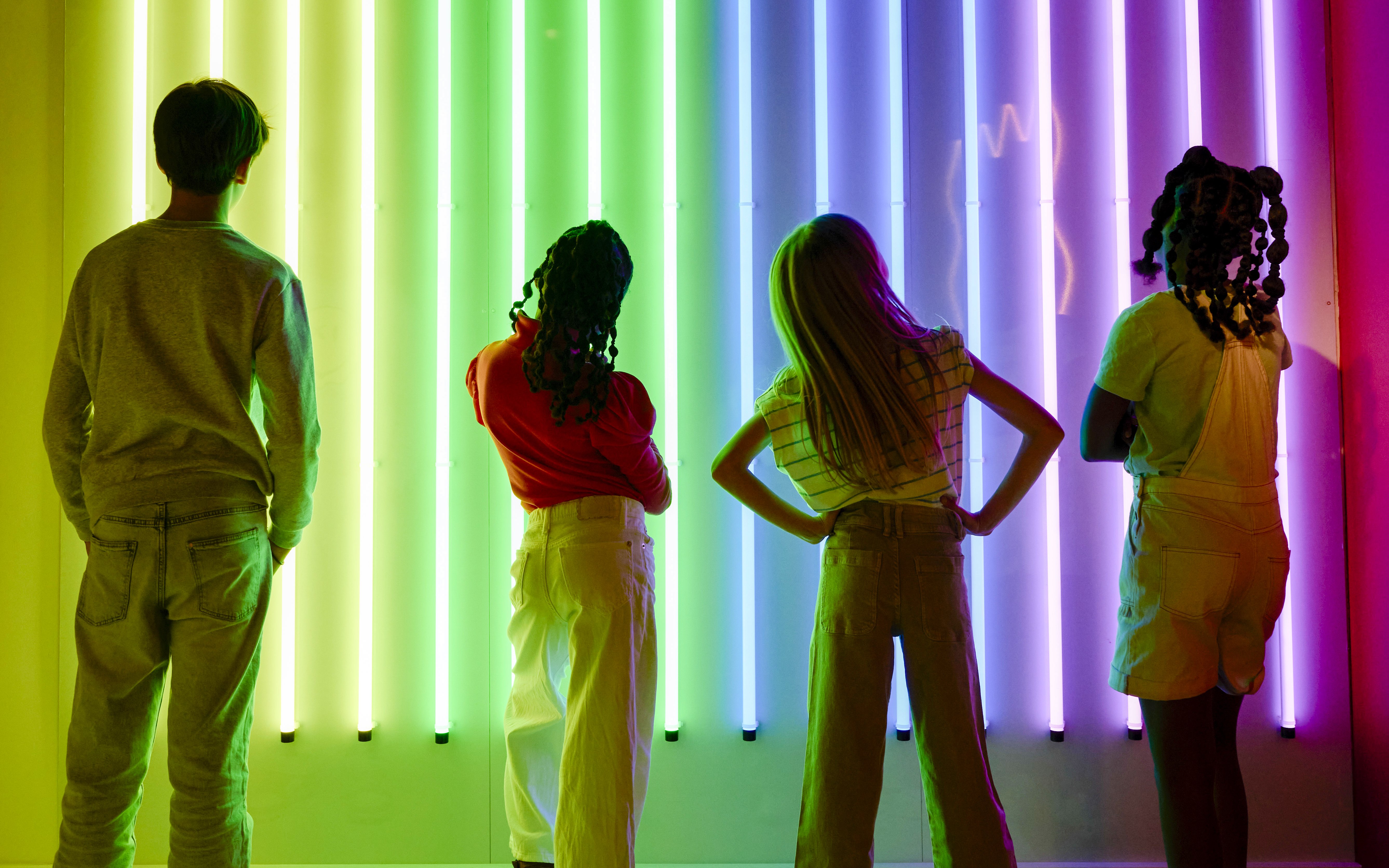 Guests viewing neon light display at Twist Museum, London.