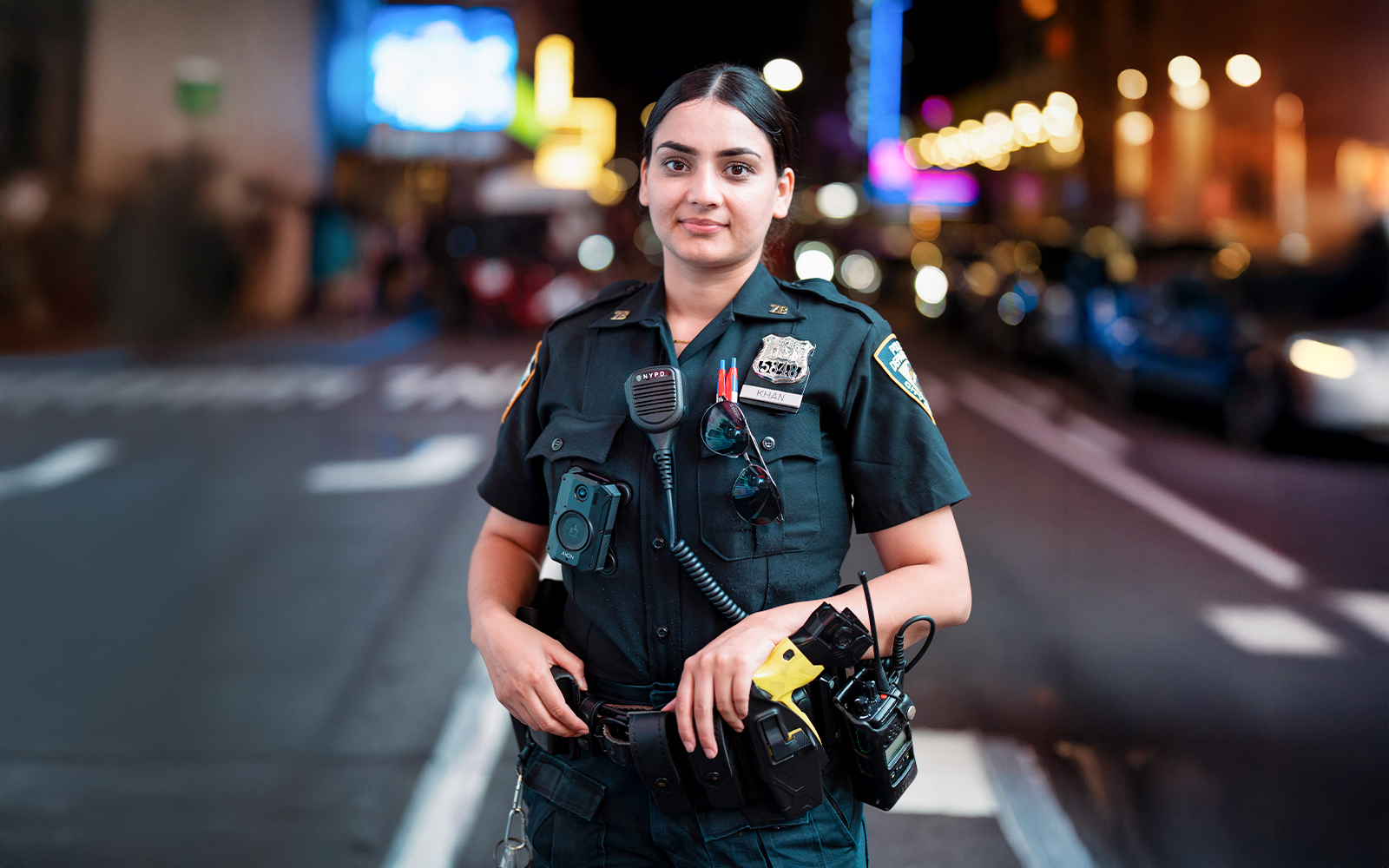 NYPD officer standing in Times Square, NYC at night.