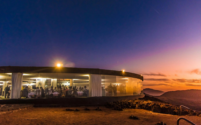 Dining at sunset in Timanfaya National Park with volcanic landscape views.
