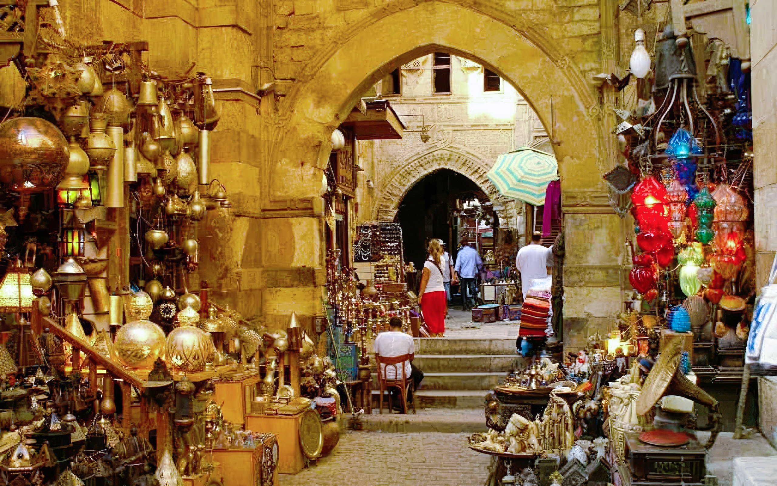 Woman exploring Khan el-Khalili bazaar in Cairo, surrounded by colorful lanterns and traditional crafts.