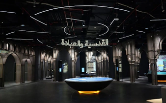 Light & Peace Museum interior at Sheikh Zayed Grand Mosque Centre, featuring illuminated arches and exhibits.