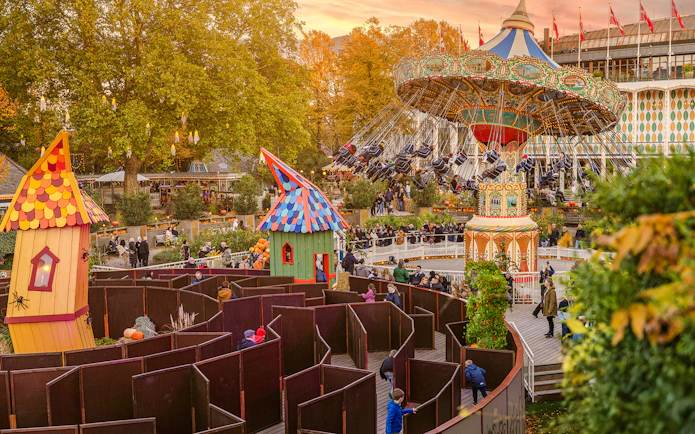 Guests enjoying Halloween rides and a maze at Tivoli Gardens, Copenhagen.