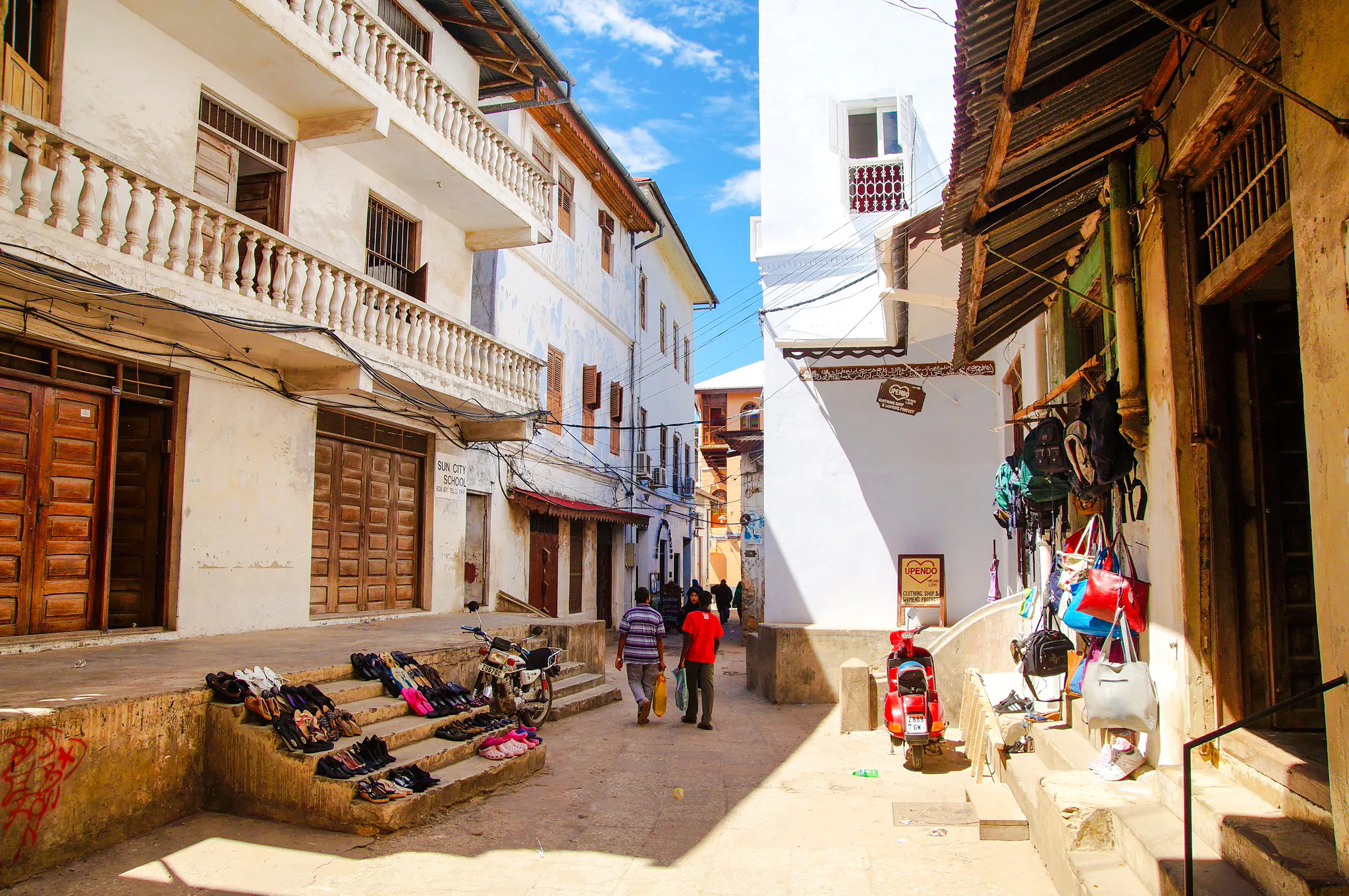 Stone Town street scene with local shops and people walking, Zanzibar.
