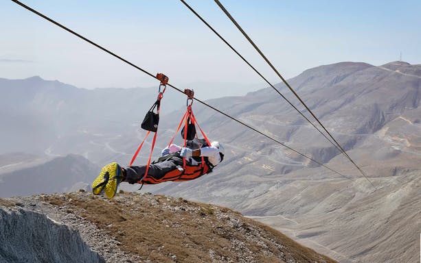 Person ziplining over Jebel Jais mountains in Ras Al Khaimah, UAE.