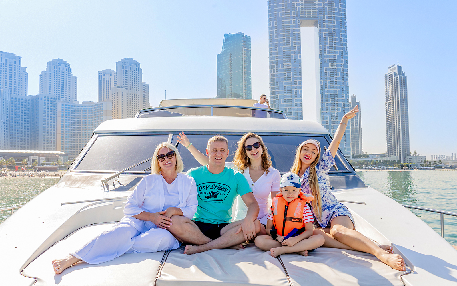 Tourists enjoying a yacht tour with Dubai skyline in the background.