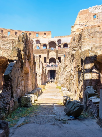 Underground level of the Colosseum in Rome showing ancient stone walls and pathways.