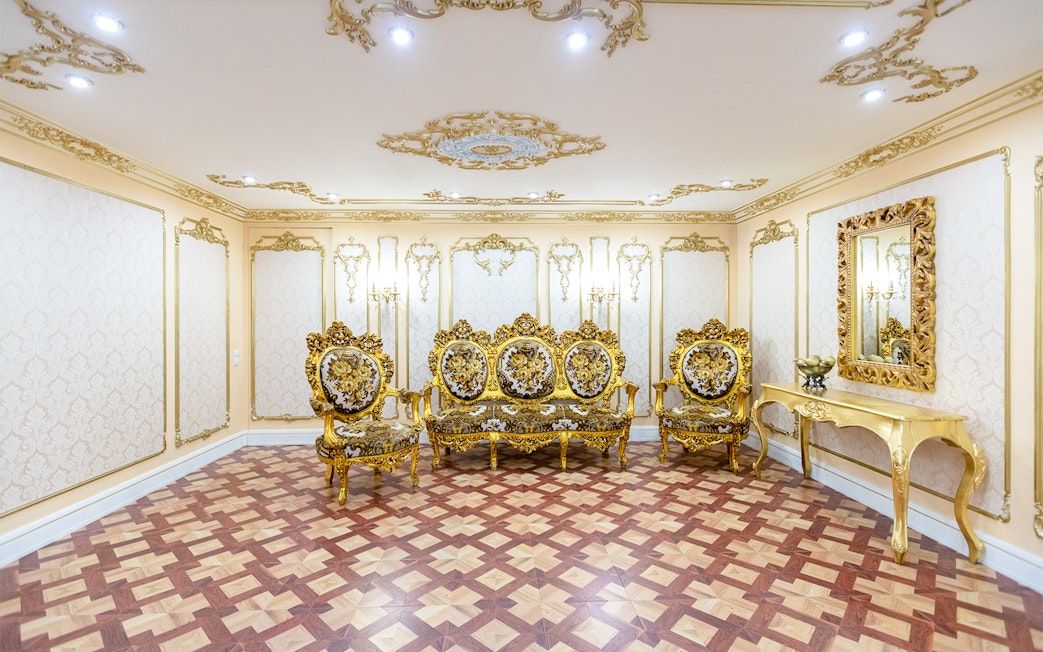 Ornate gold furniture in a lavish room inside the Royal Palace of Madrid.