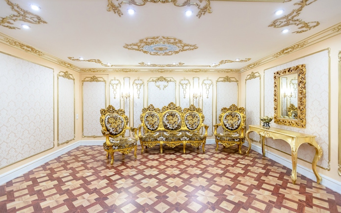Ornate gold furniture in a lavish room inside the Royal Palace of Madrid.