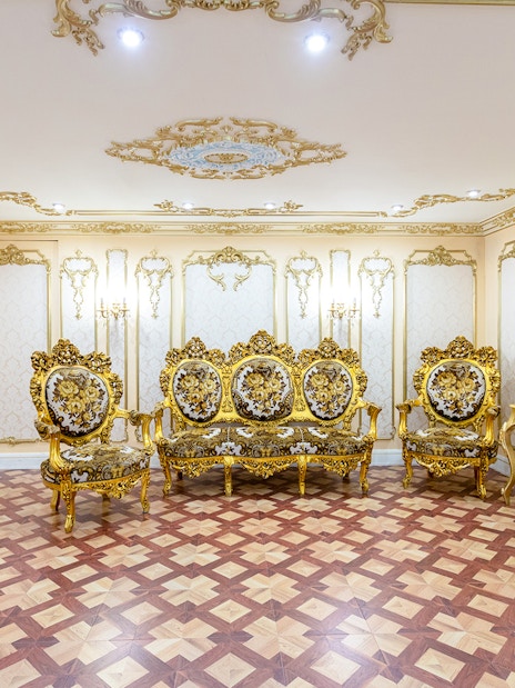 Ornate gold furniture in a lavish room inside the Royal Palace of Madrid.