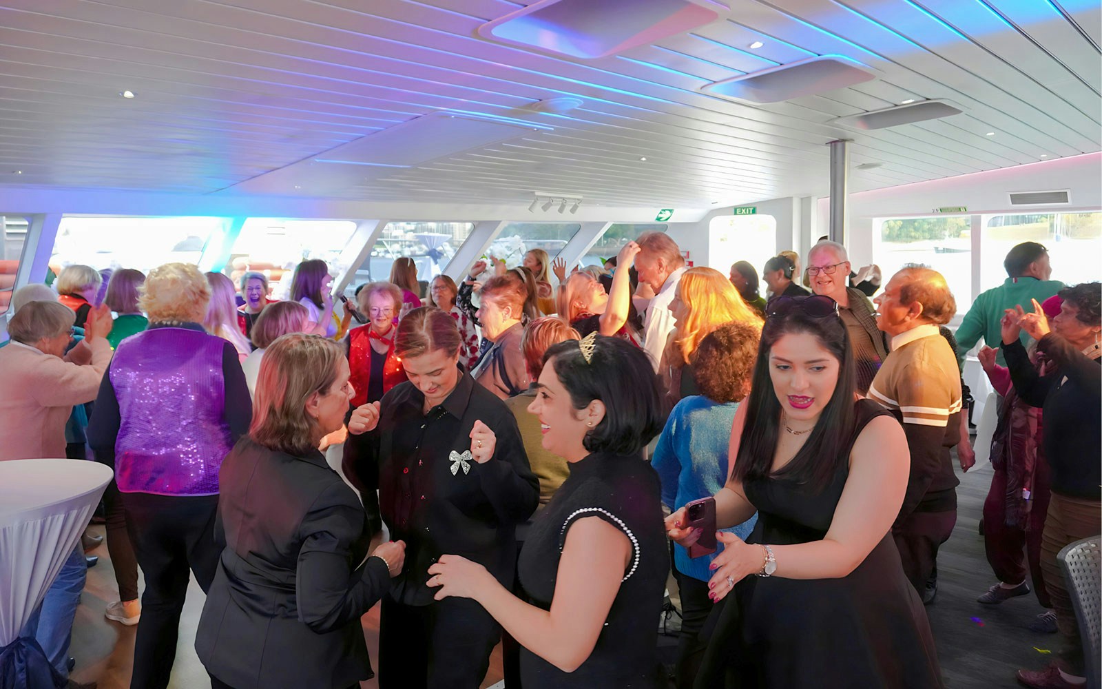 People dancing at Abba Tribute Show Cruise in Sydney.