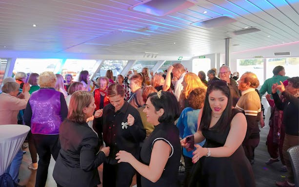 People dancing at Abba Tribute Show Cruise in Sydney.