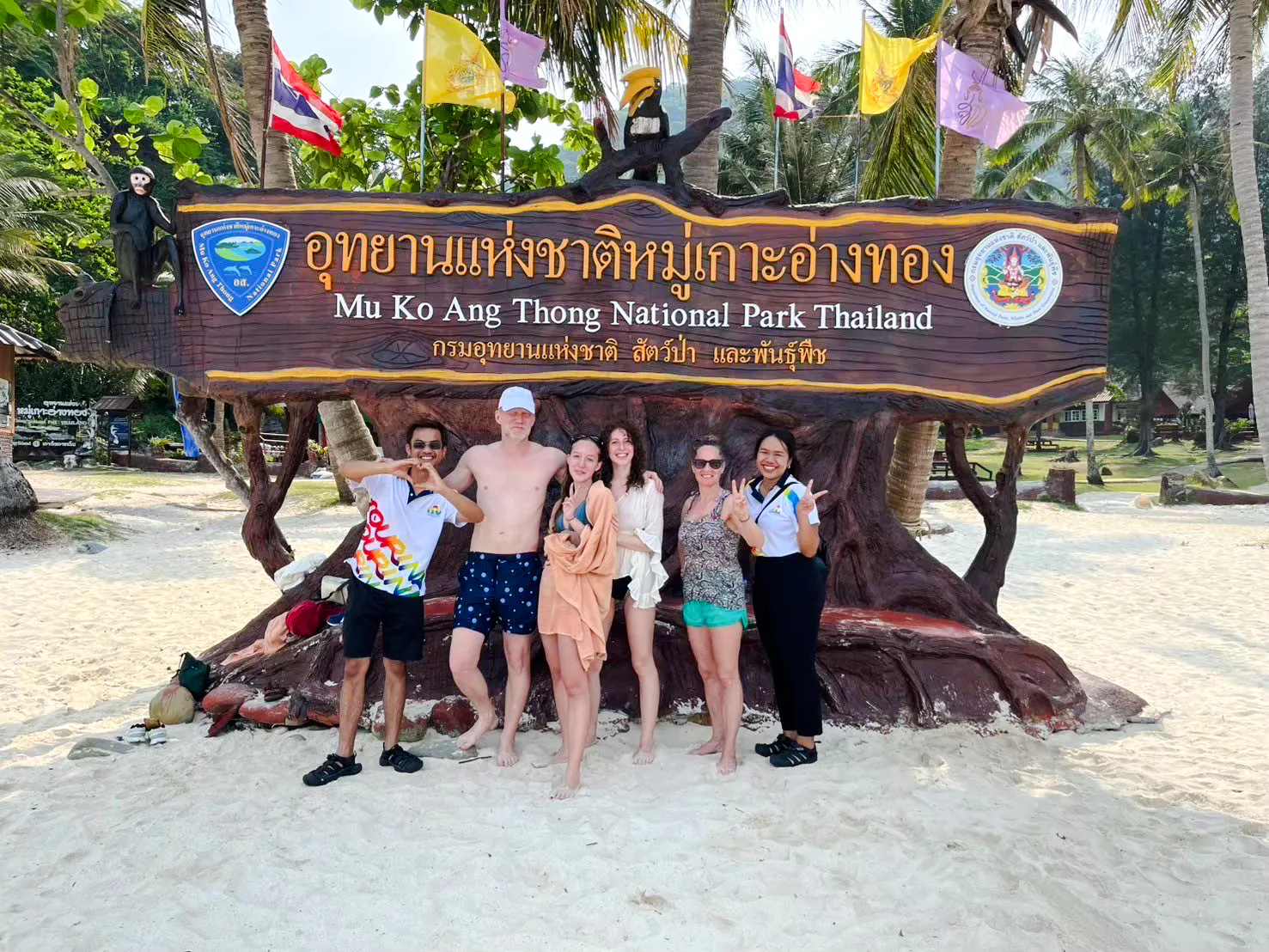 Group posing at Mu Ko Ang Thong National Park sign, Koh Samui, during island hopping adventure.