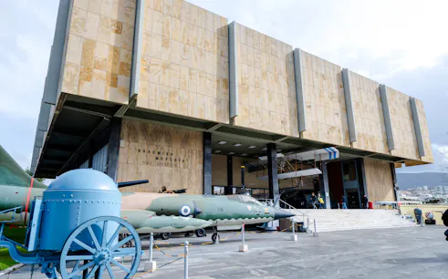 Athens War Museum entrance with military aircraft and artillery display.