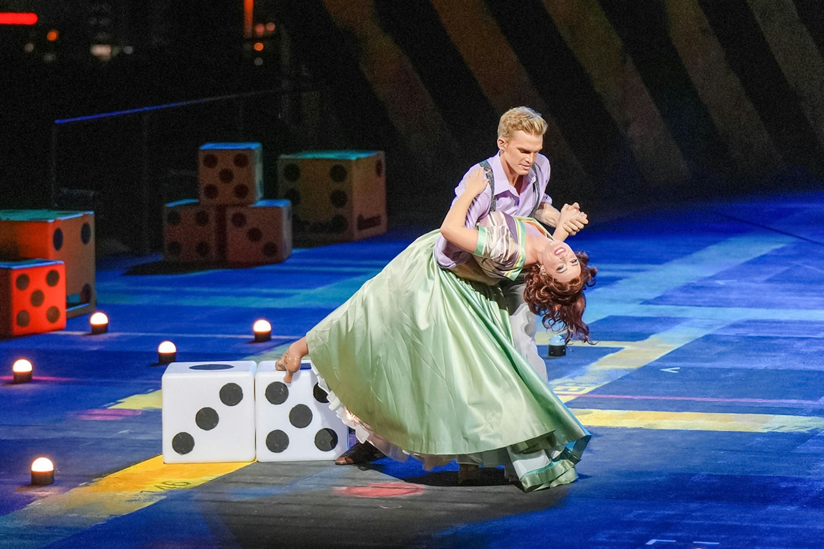 Dancers performing Guys & Dolls on Sydney Harbour stage with large dice props.