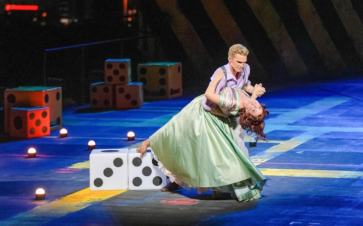 Dancers performing Guys & Dolls on Sydney Harbour stage with large dice props.