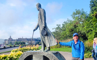 Statue of Nikola Tesla with a visitor at Niagara Falls park.