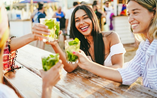 Friends enjoying drinks at a beach bar.
