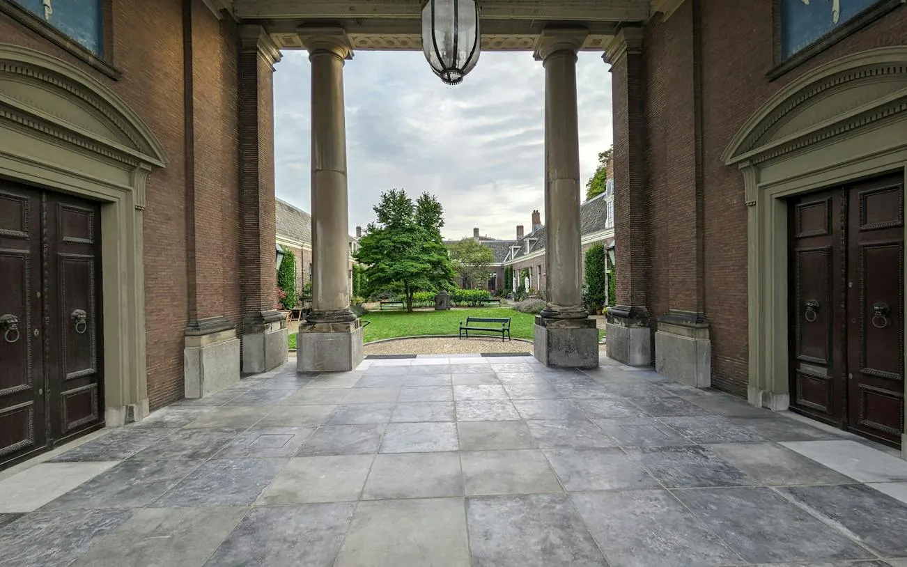 Courtyard view through columns at historic site in Haarlem, part of self-guided city exploration game.