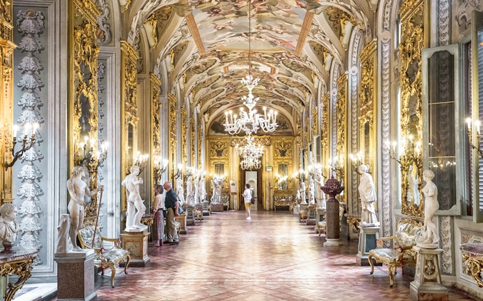 Doria Pamphilj Gallery hall with ornate ceiling, chandeliers, and classical statues in Rome.