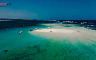 Glass-bottom boats near Robinson Island, Diani Beach, with clear turquoise waters.