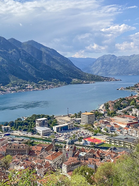 Kotor Bay view with cruise ship, mountains, and historic buildings in Montenegro.