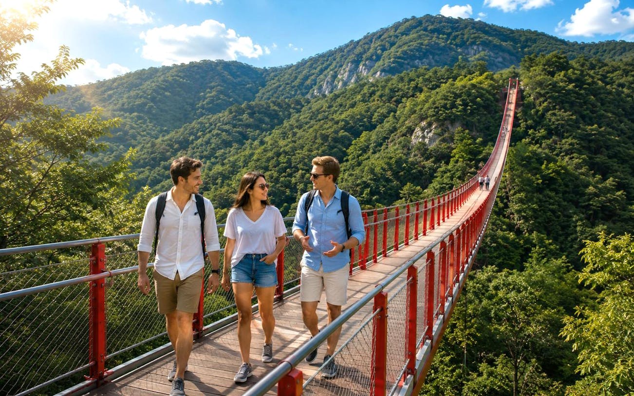 Visitors walking on a suspension bridge with lush mountains in the background during DMZ full-day tour.