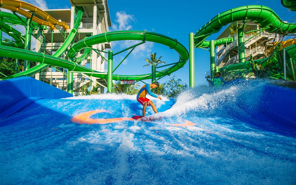 Boy surfing on Flow Rider at Waterbom Bali water park, Indonesia.