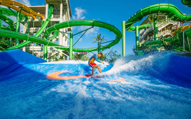 Boy surfing on Flow Rider at Waterbom Bali water park, Indonesia.