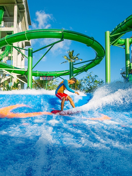 Boy surfing on Flow Rider at Waterbom Bali water park, Indonesia.