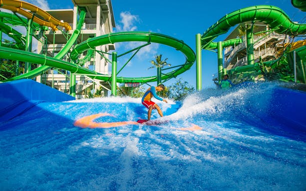Boy surfing on Flow Rider at Waterbom Bali water park, Indonesia.