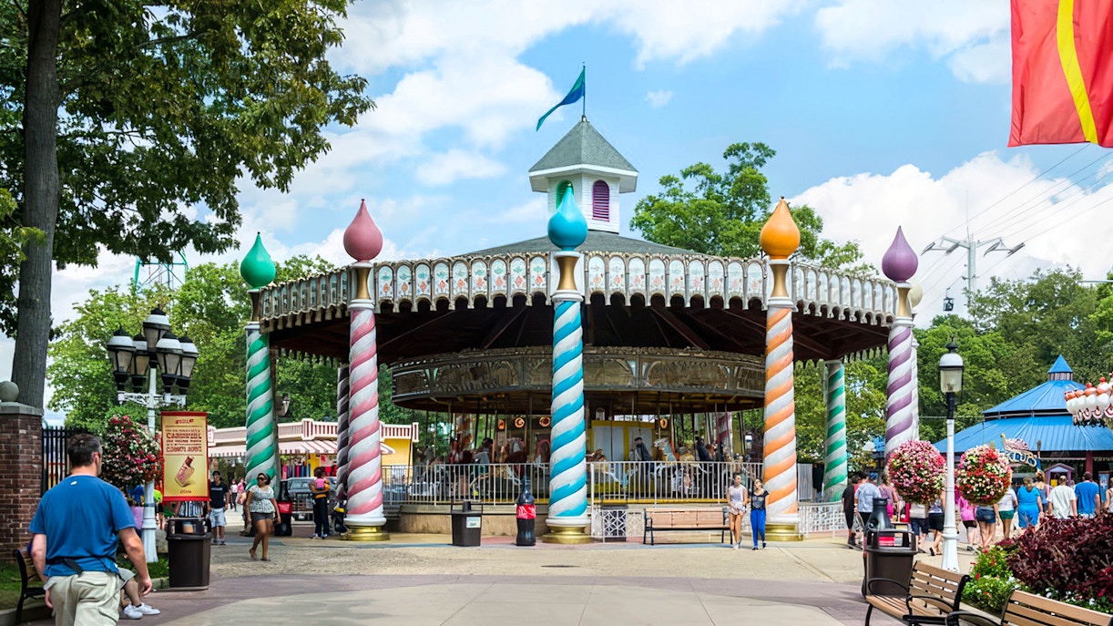 Carousel at Six Flags Great Adventure with colorful pillars and visitors nearby.