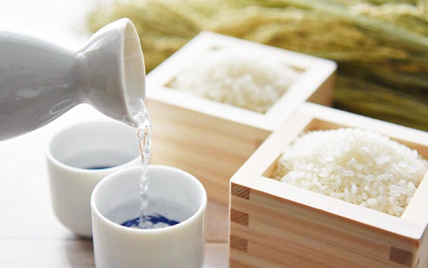 Sake being poured into cups with rice grains at Seibu Ikebukuro Main Branch.