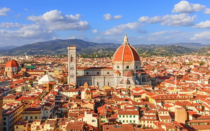 Florence Cathedral and Duomo with cityscape and hills in the background.