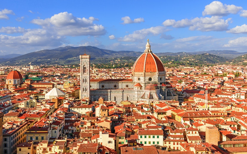 Florence Cathedral and Duomo with cityscape and hills in the background.