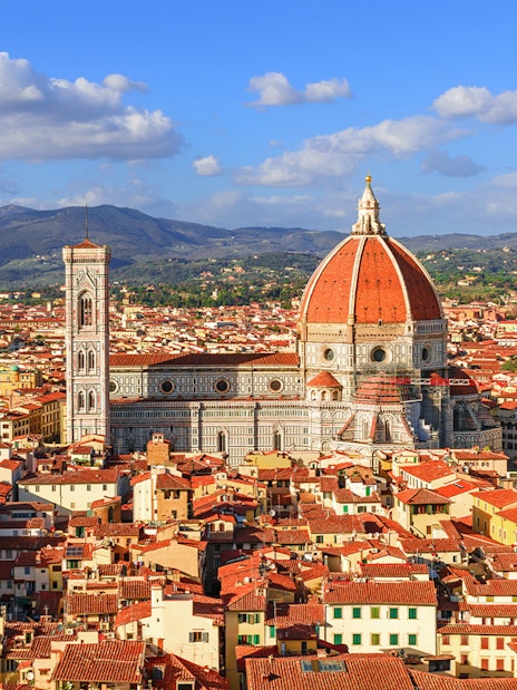 Florence Cathedral and Duomo with cityscape and hills in the background.