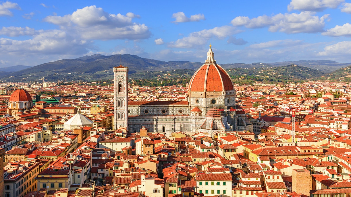 Florence Cathedral and Duomo with cityscape and hills in the background.