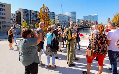Tour group exploring HafenCity with Elbphilharmonie in the background, Hamburg.