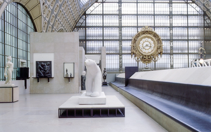 Interior of Musée d'Orsay, Paris, featuring sculptures and a large ornate clock.
