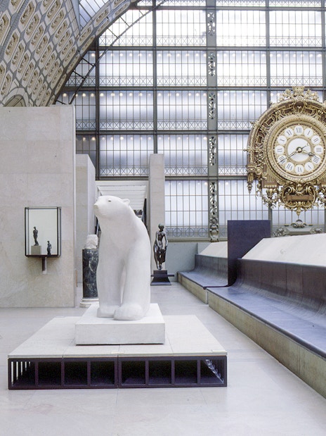 Interior of Musée d'Orsay, Paris, featuring sculptures and a large ornate clock.