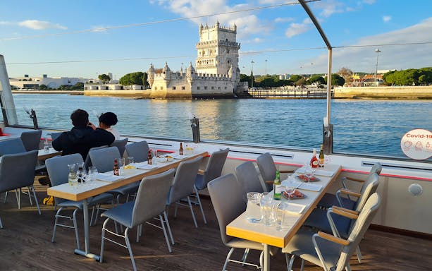 Sunset cruise on Tagus River with view of Belém Tower in Lisbon.