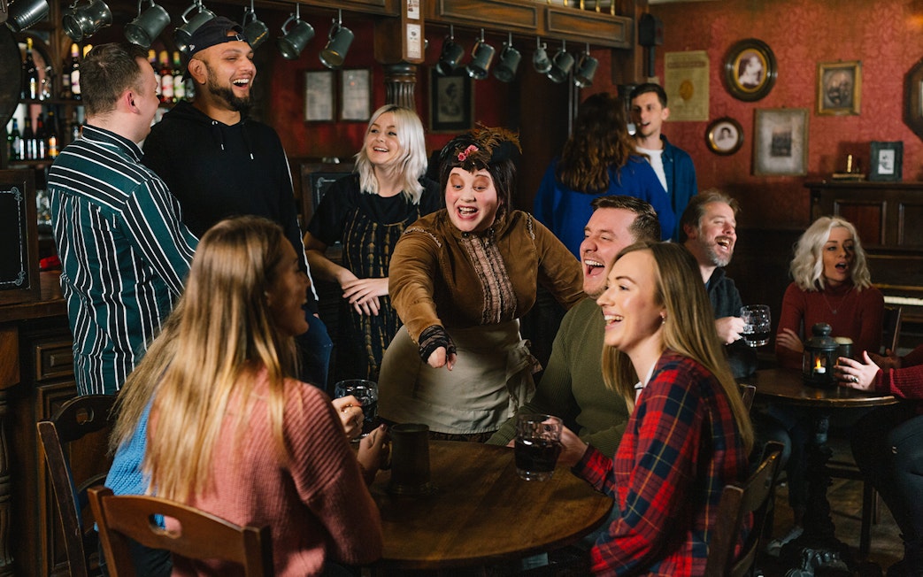 Guests enjoying drinks and entertainment at the London Dungeon Tavern.