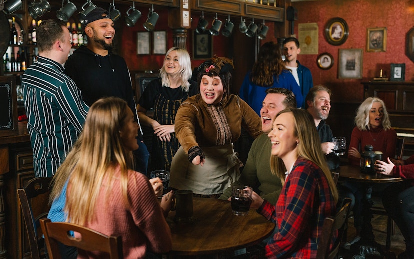 Guests enjoying drinks and entertainment at the London Dungeon Tavern.