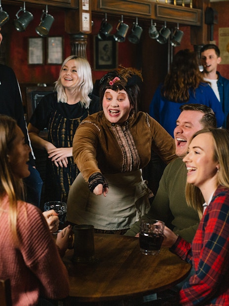Guests enjoying drinks and entertainment at the London Dungeon Tavern.