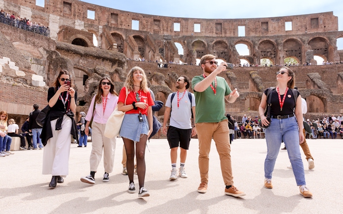 Visitors exploring the Colosseum arena during a guided tour in Rome.