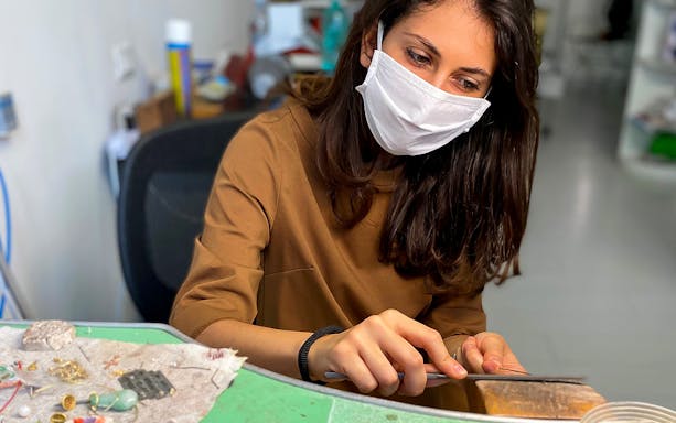 Jewelry-making workshop participant crafting in Oristano, Sardinia.