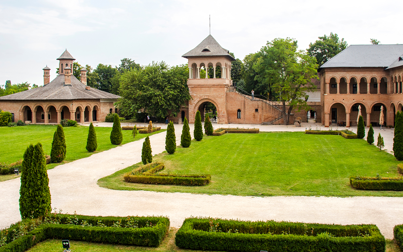 Mogosoaia Palace courtyard with manicured gardens and historic brick architecture, Romania.