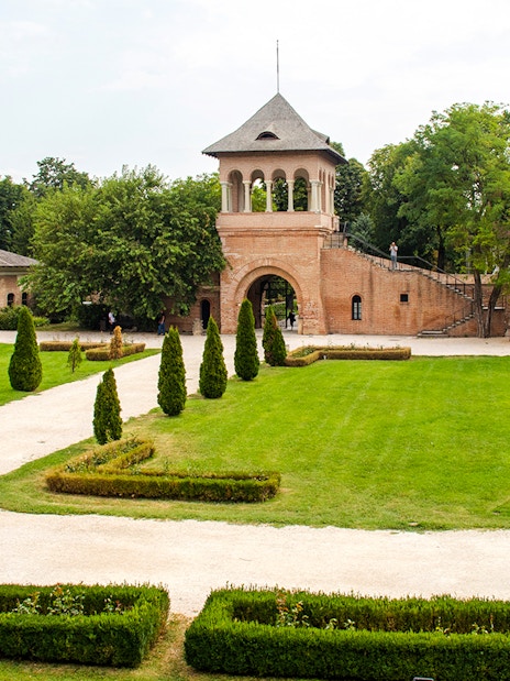 Mogosoaia Palace courtyard with manicured gardens and historic brick architecture, Romania.