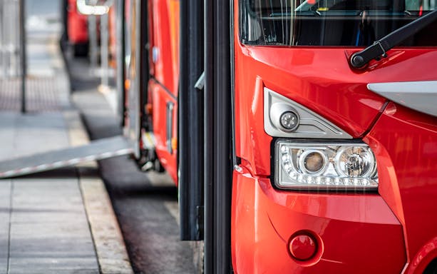 Red bus at Ibiza Airport terminal for one-way transfer to Ibiza.